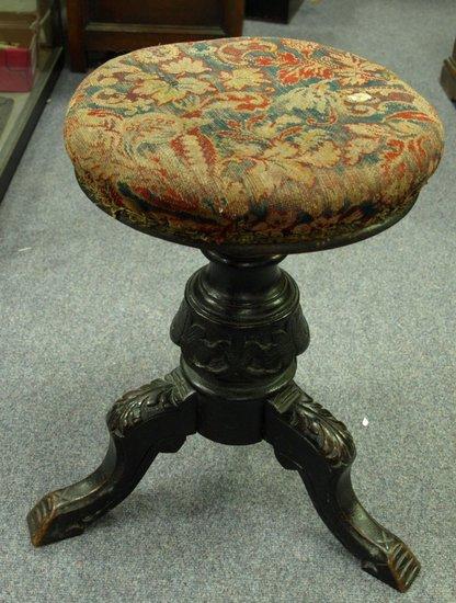 Appraisal: A Victorian carved walnut revolving piano stool on three hipped