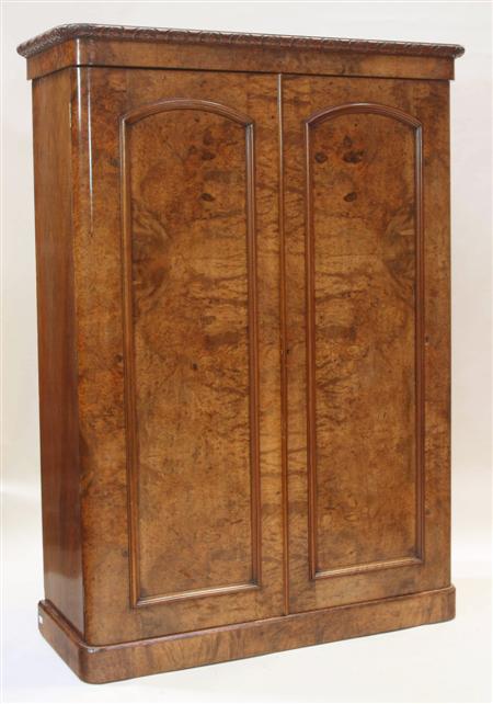 Appraisal: A Victorian burr walnut wardrobe the carved projected cornice over