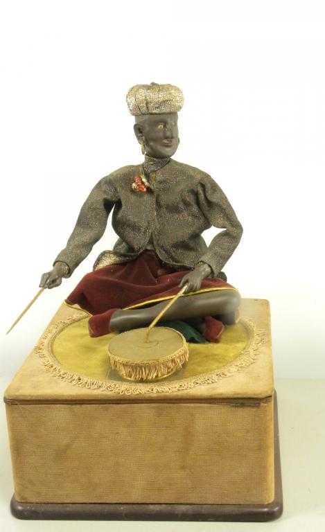 Appraisal: Automaton An Eastern magician seated crossed legged on velvet covered