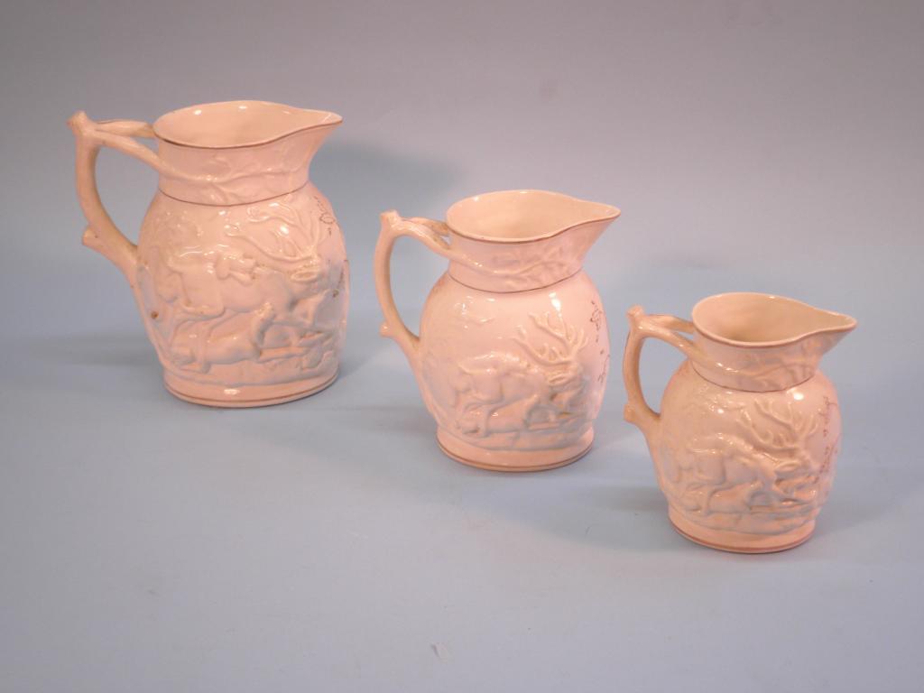 Appraisal: A graduated set of three thC Staffordshire jugs each moulded