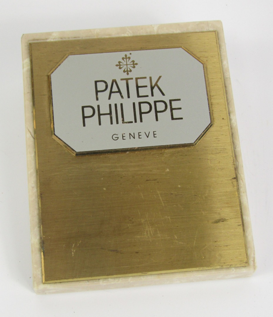 Appraisal: A Patek Philipe brass and marble advertising paperweight of wedge