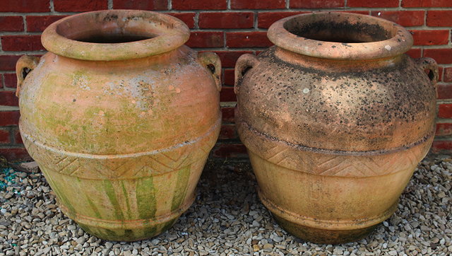 Appraisal: A PAIR OF TERRACOTTA OIL JARS with lug handles and