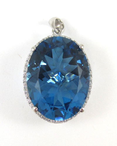 Appraisal: BLUE TOPAZ AND FOURTEEN KARAT WHITE GOLD PENDANT with round-cut