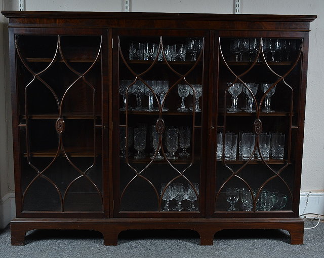 Appraisal: An Edwardian mahogany bookcasewith three glazed doors to front enclosing