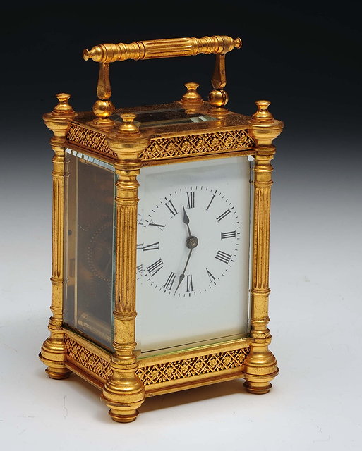 Appraisal: A brass and gilt carriage clockwith enamel dial swing handle