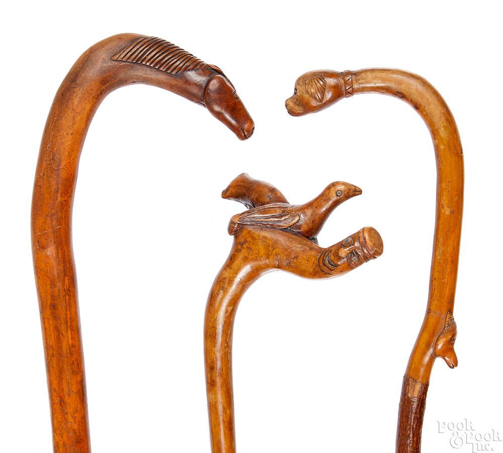 Appraisal: Three carved canes Three carved canes ca with animal grips