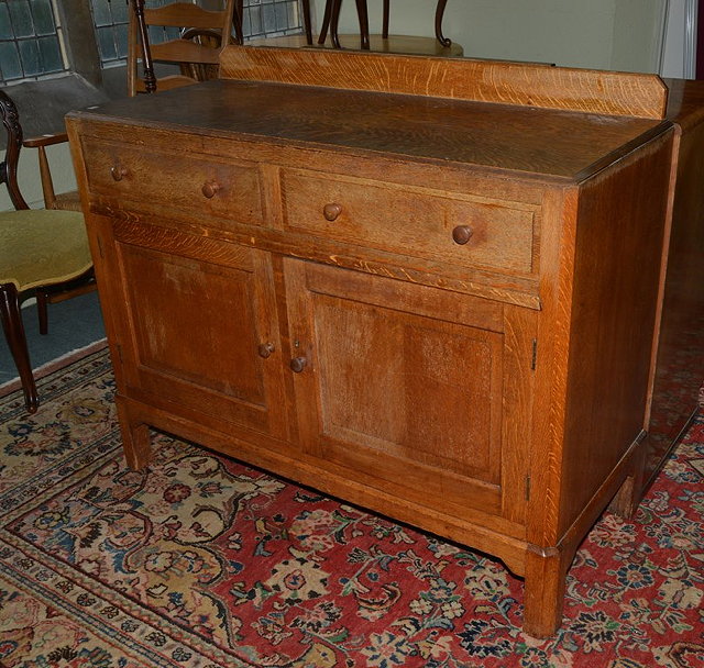 Appraisal: A HEALS OAK SIDEBOARD fitted two drawers and two cupboards