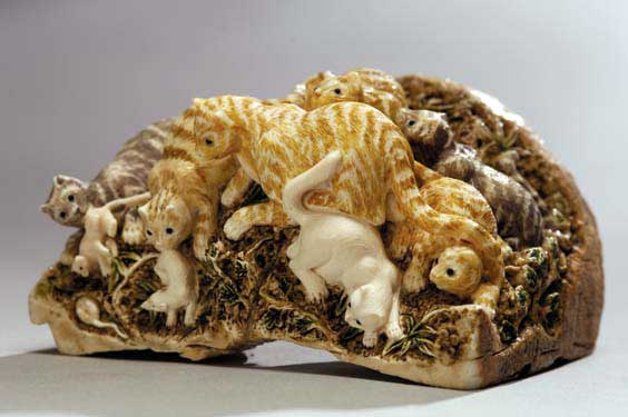 Appraisal: CARVED FOSSIL IVORY OKIMONO CAT GROUP Charming and well carved