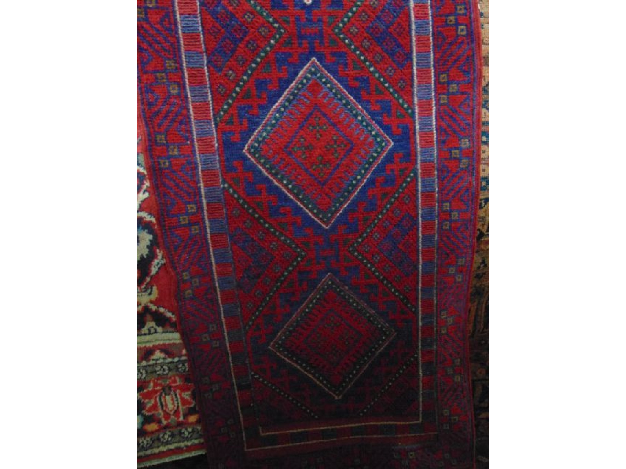 Appraisal: A woven wool runner with alternating red and blue field