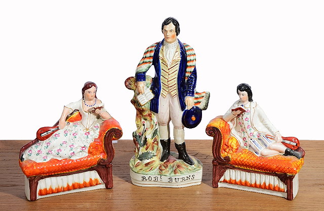 Appraisal: A PAIR OF STAFFORDSHIRE POTTERY FIGURES of a girl and