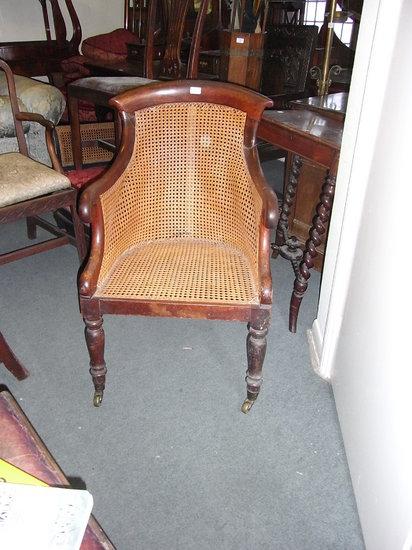 Appraisal: A TH CENTURY MAHOGANY BERGERE ARMCHAIR with cane seat and