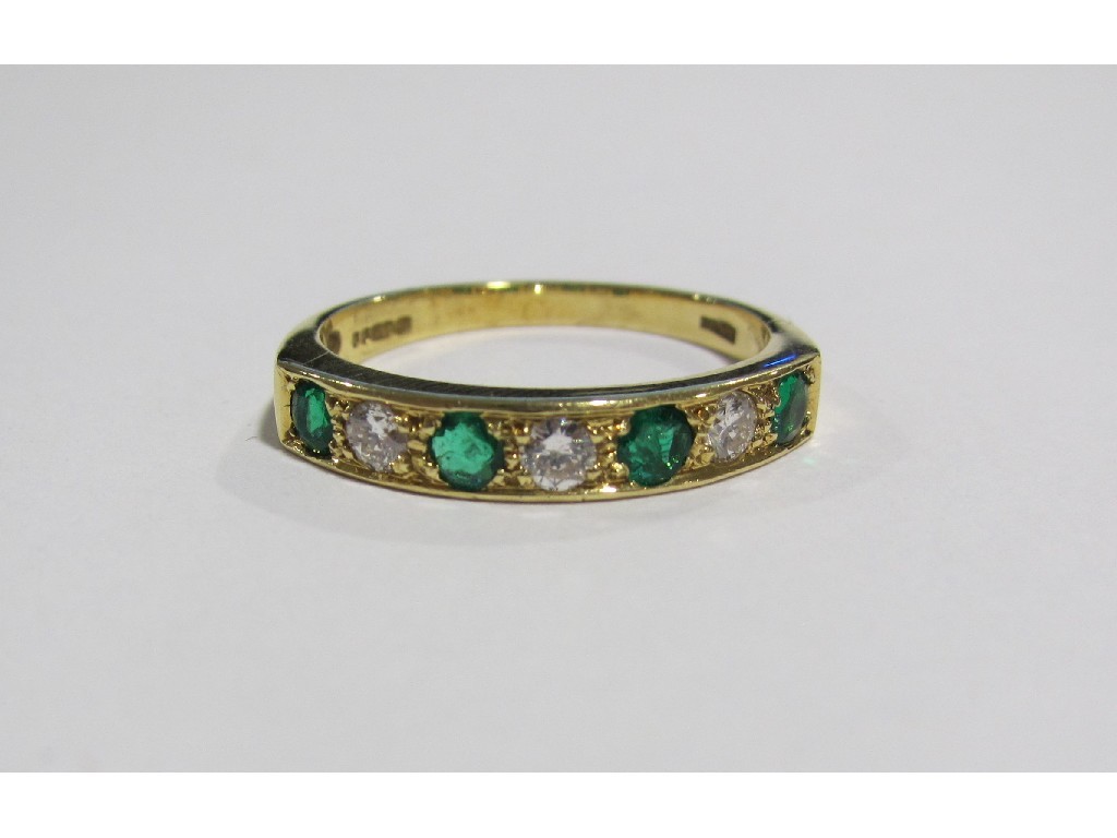 Appraisal: An eighteen carat gold emerald and diamond seven half hoop