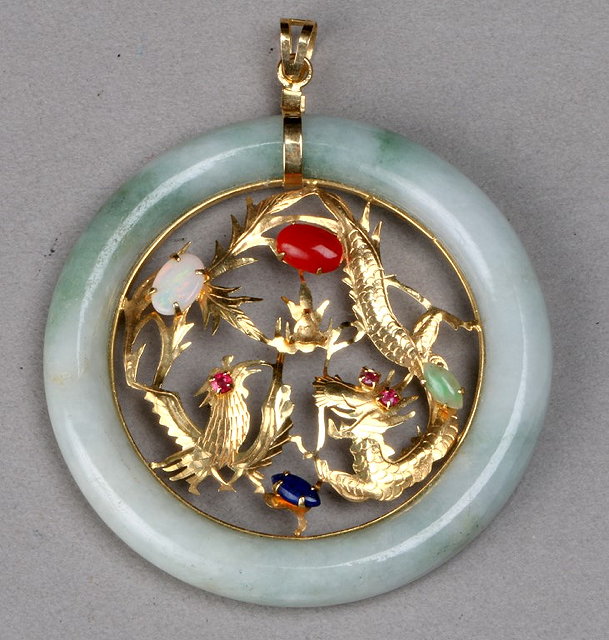 Appraisal: A CHINESE JADE PENDANT the centre mounted with pierced gem