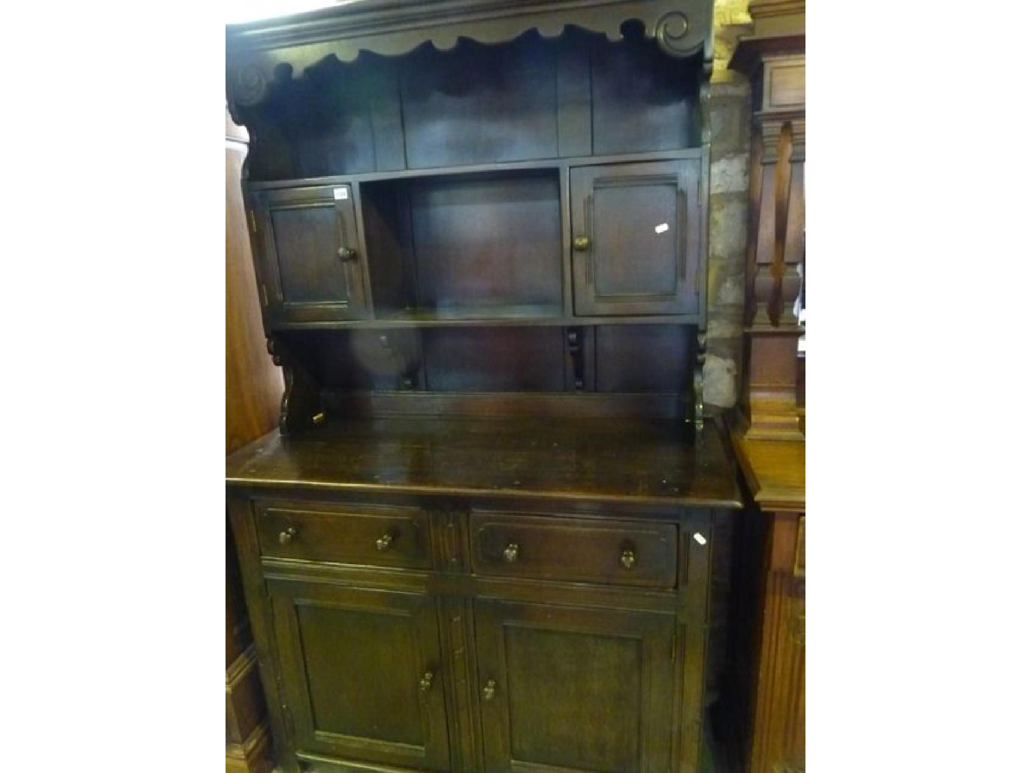 Appraisal: A reproduction oak cottage dresser the raised plate rack partially