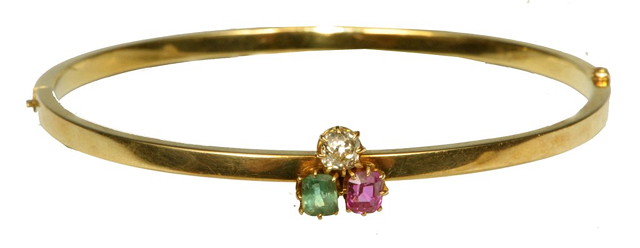 Appraisal: A RUBY EMERALD AND DIAMOND SET HINGED BANGLE claw set