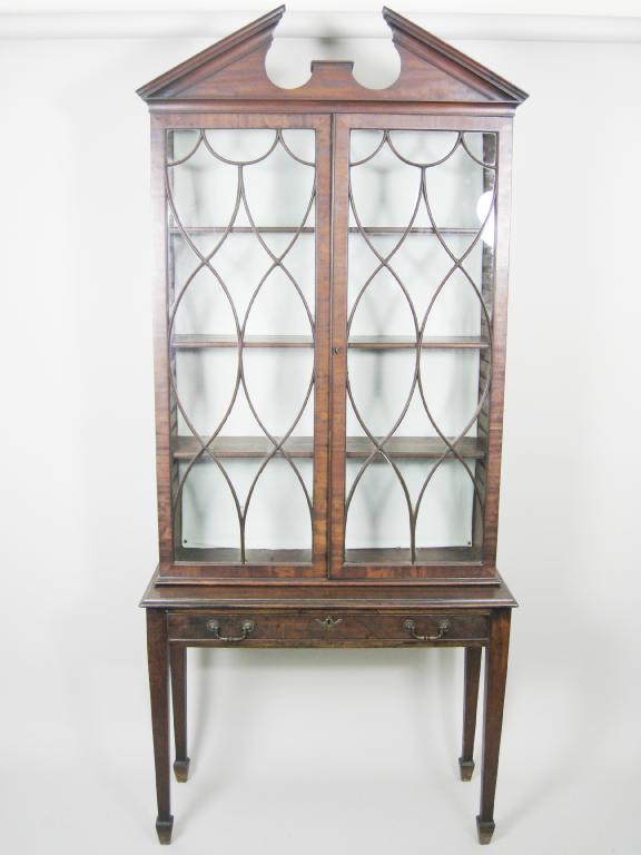 Appraisal: A Georgian mahogany glazed Bookcase on Stand with broken arched