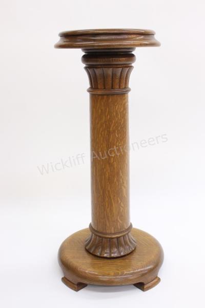 Appraisal: An antique golden oak pedestal with fluted top and base