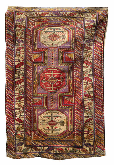 Appraisal: A PURPLE GROUND CAUCASIAN RUG centrally decorated with three medallions