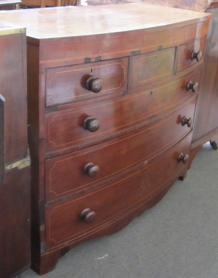 Appraisal: An early Victorian inlaid mahogany bowfront chest with three short