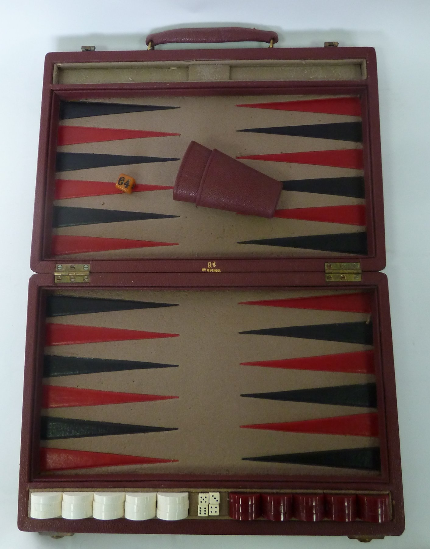 Appraisal: A travel backgammon board in maroon case complete with dice