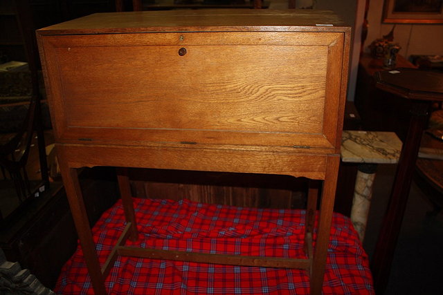 Appraisal: A COTSWOLD SCHOOL OAK FALL FRONT BUREAU with plain panel