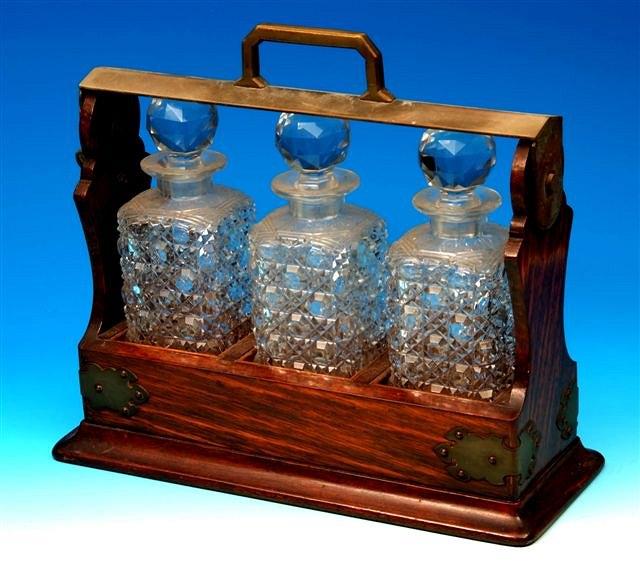 Appraisal: A late Victorian oak tantalus with three cut glass decanters