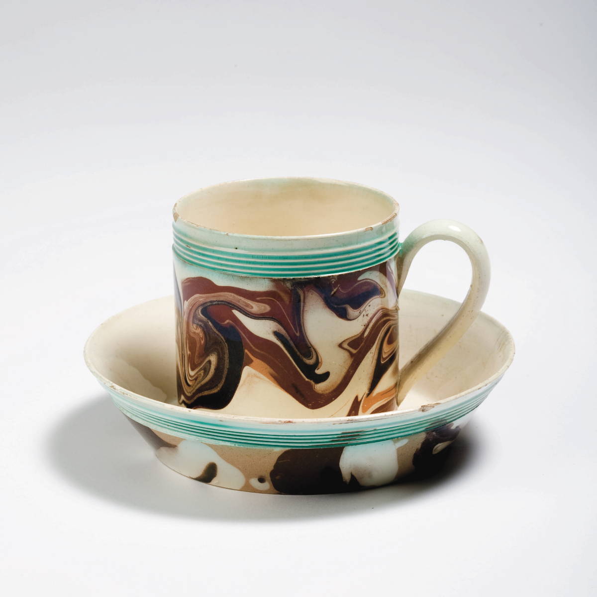 Appraisal: BRITISH CREAMWARE MOCHAWARE CAN AND SAUCER CIRCA Each slip-marbled in