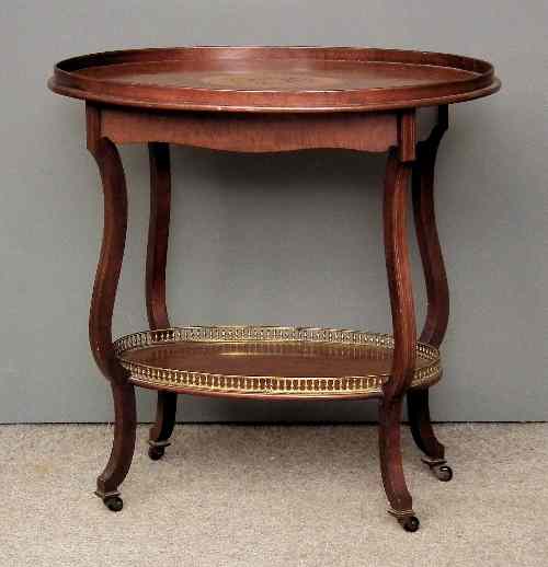 Appraisal: An Edwardian oval two tier occasional table the top with