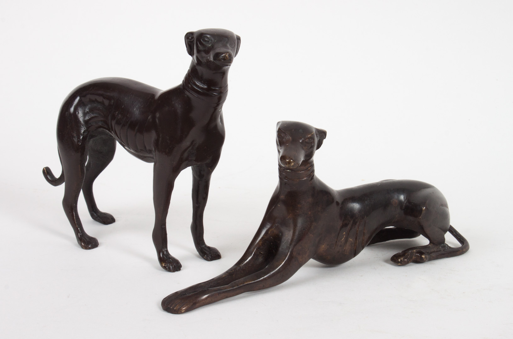 Appraisal: Two bronze greyhound sculptures Standing and recumbent greyhounds in H