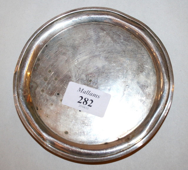 Appraisal: A GEORGE III SILVER BOTTLE COASTER with reeded edge and