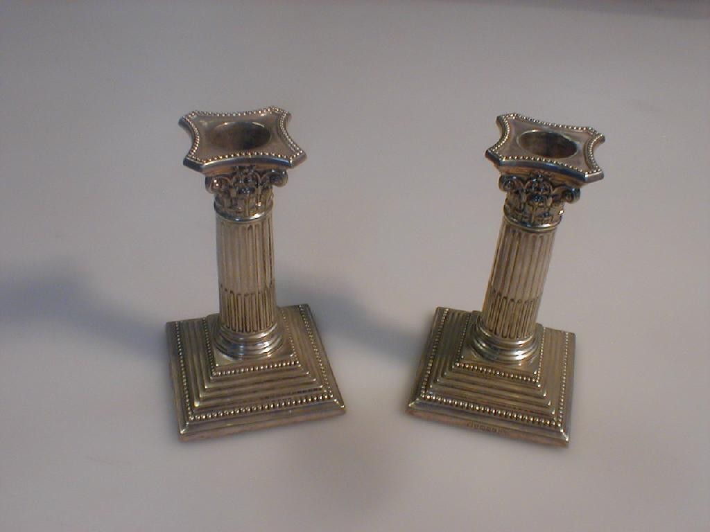 Appraisal: A pair of Walker Hall Corinthian columnar electroplate candlesticks inches