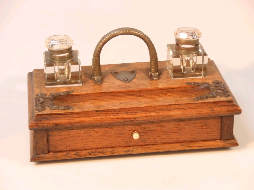 Appraisal: A late Victorian oak desk stand with metal loop carrying