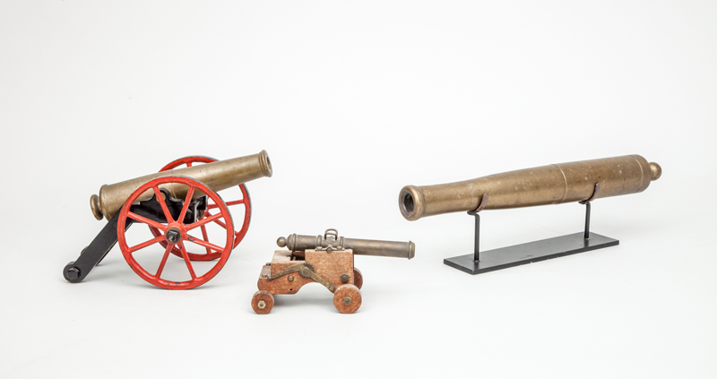 Appraisal: BRASS MODEL OF A CANNON ON CAST-IRON RED AND BLACK