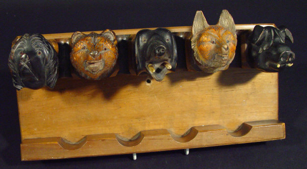 Appraisal: Black Forest style pipe rack surmounted with five carved wooden