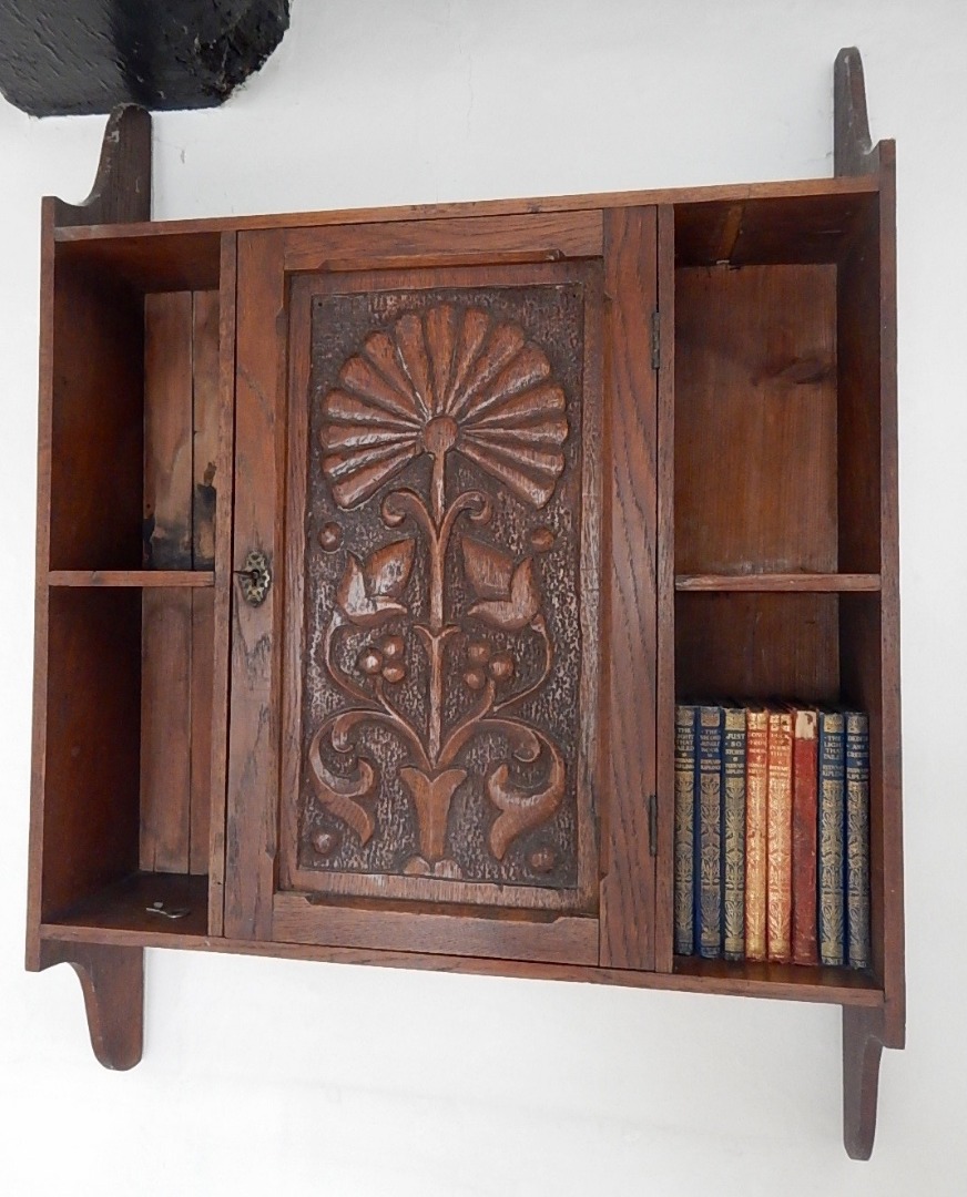 Appraisal: An Edwardian carved oak wall hanging cabinet enclosed by a