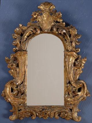 Appraisal: CONTINENTAL BAROQUE CARVED GILTWOOD MIRROR The arched plate flanked by