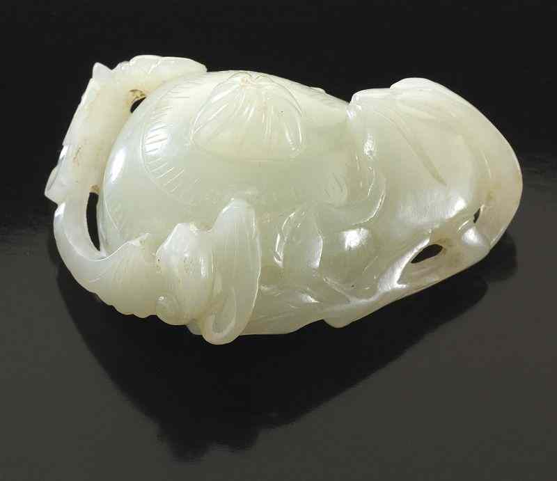 Appraisal: Chinese Qing carved white jade toggledepicting water chestnuts plum blossoms