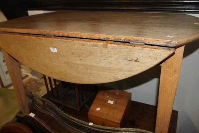 Appraisal: A STRIPPED AND WAXED OAK KITCHEN TABLE with drop flaps