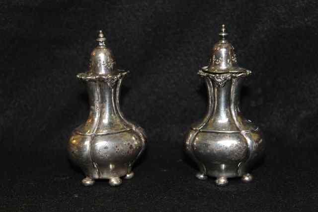 Appraisal: A PAIR OF SILVER PEPPER POTS of baluster form with