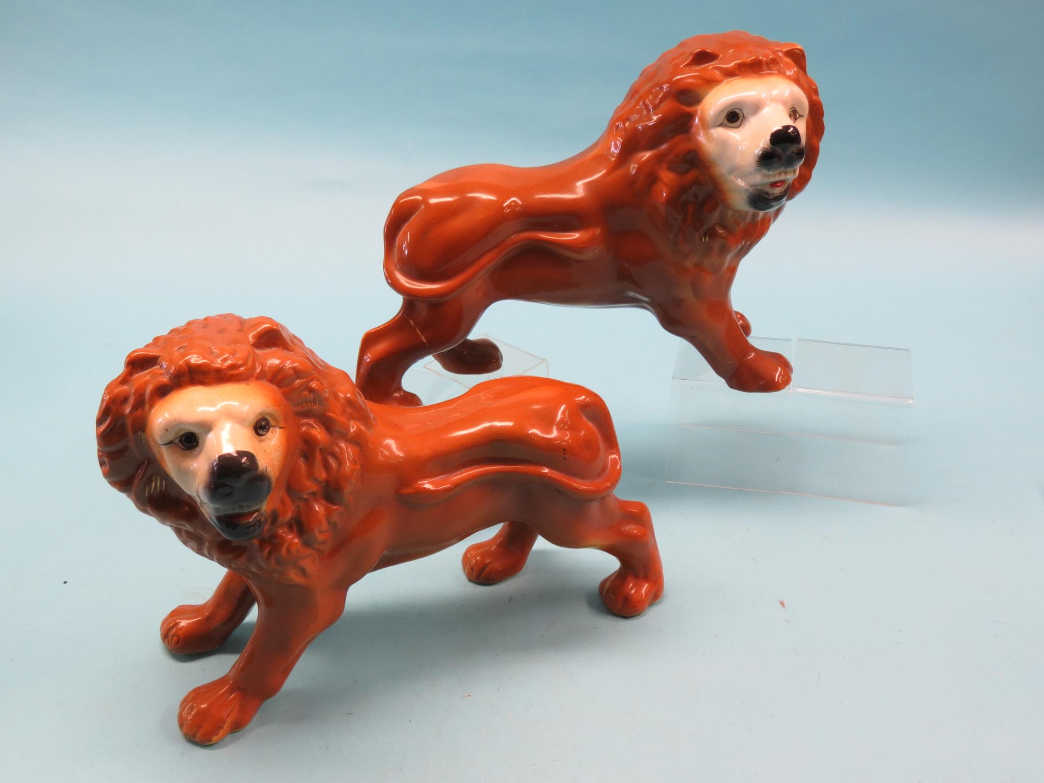 Appraisal: A pair of Staffordshire pottery lion models each standing four-square