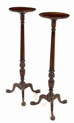 Appraisal: A pair of carved mahogany torcheres in George III style