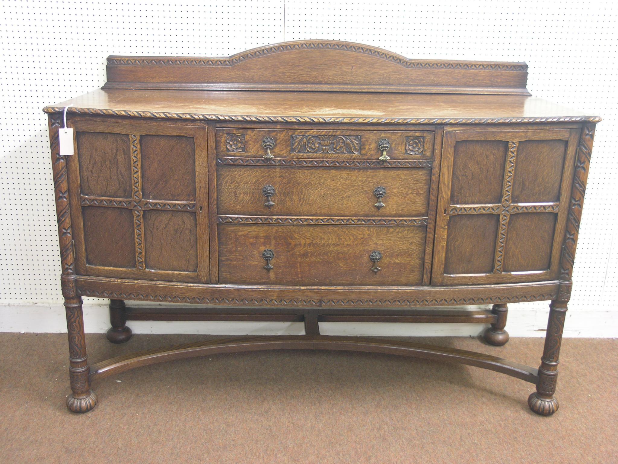 Appraisal: A solid dark oak sideboard bow-fronted with three drawers and