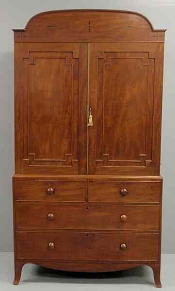 Appraisal: English mahogany two-part linen press with an ebony inlaid arched