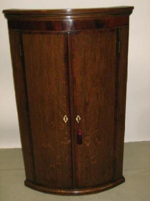 Appraisal: A GEORGE III OAK CORNER CUPBOARD of quadrant form with