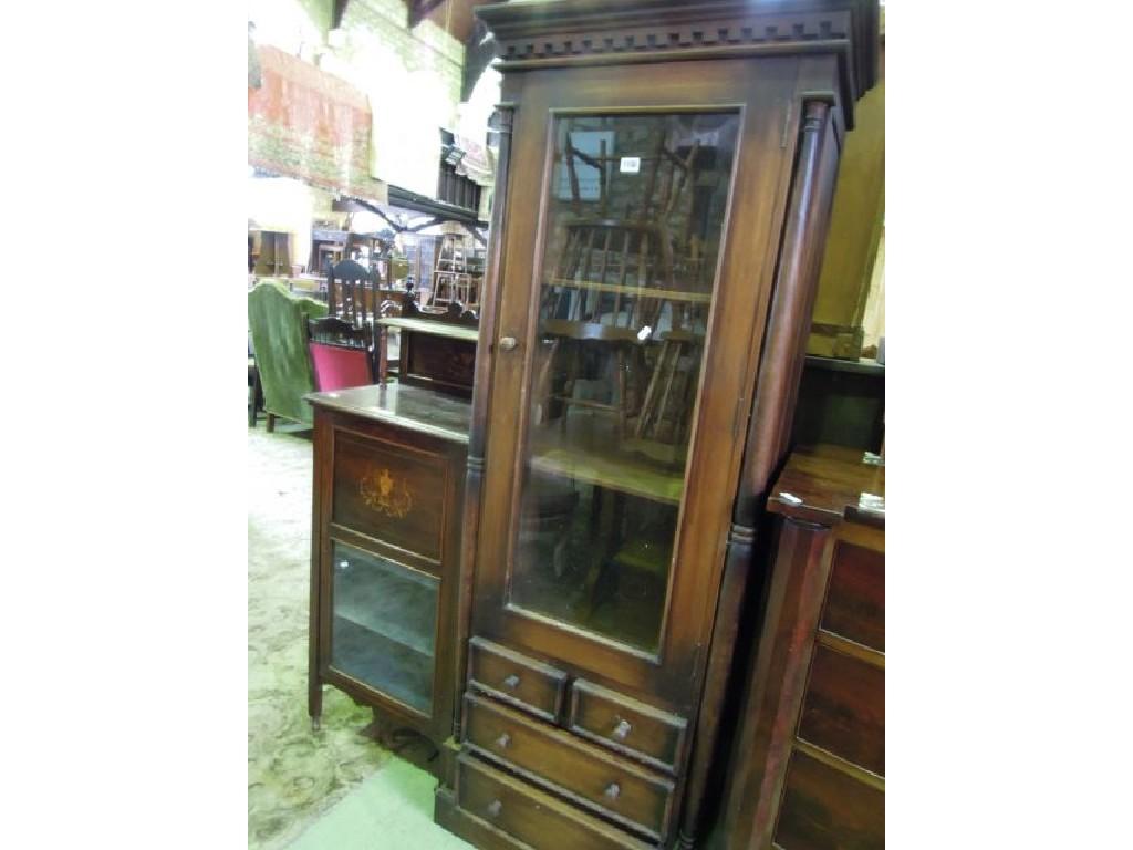 Appraisal: A freestanding hardwood display cabinet with stepped and moulded cornice