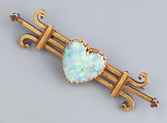 Appraisal: AN OPAL SET BROOCH the trifurcated bar with scrolled terminals