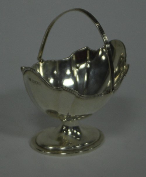 Appraisal: A swing handled silver sugar basket TB London with shaped