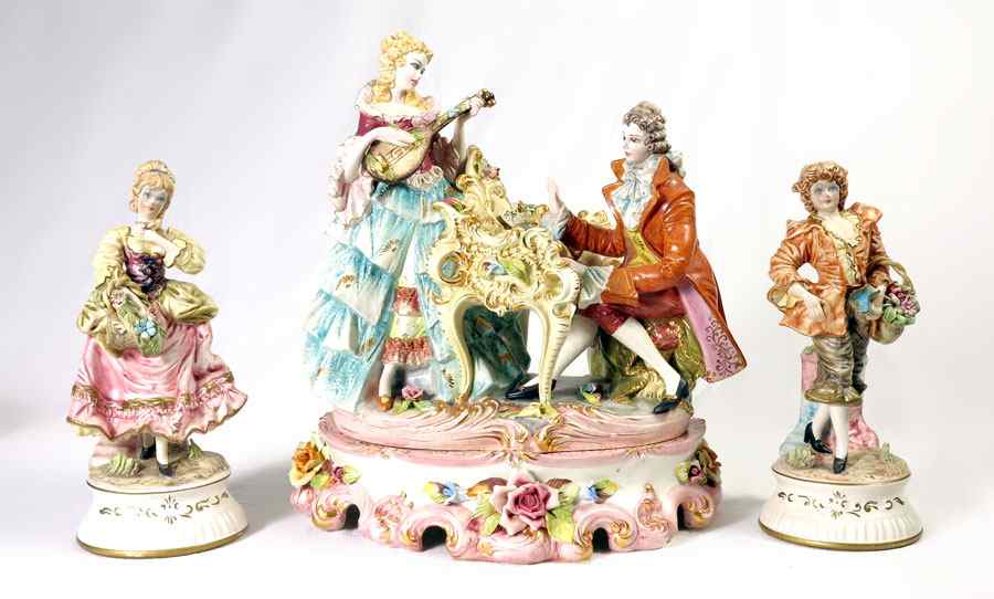 Appraisal: ITALIAN CERAMIC FIGURAL GROUP AND GARNITURE FIGURINES Musical couple festooned