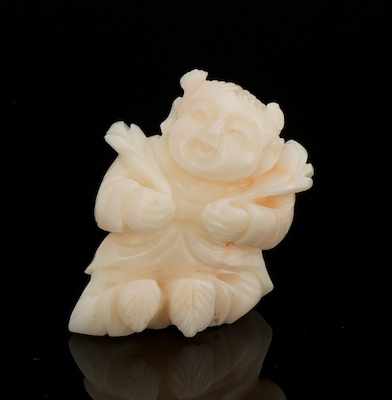 Appraisal: A Carved Angel Skin Coral Figure of a Boy Depicting