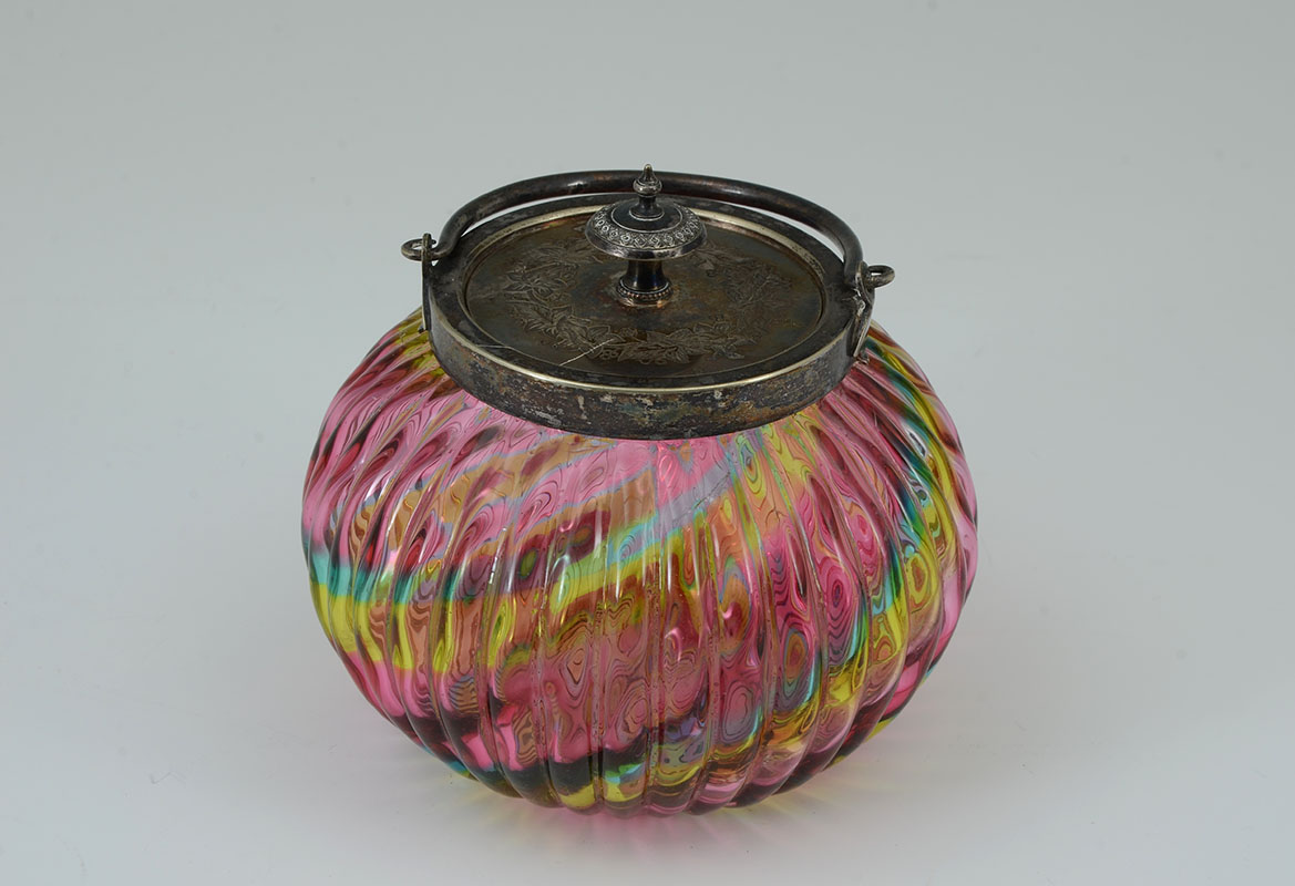 Appraisal: POLYCHROME SWIRL RIBBED GLASS BISCUIT JAR Engraved silverplate lid articulated